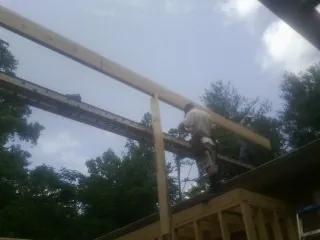 Carpenter setting a ridge beam over a new addition frame — Ice Dam Removal by Roofing Brothers in Ridgeland